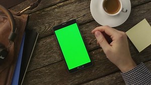 Using Android Phone Which Laying on Wooden Table at Home. Top View. Causal Lifestyle