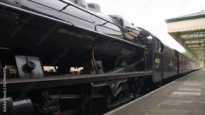 Steam engine train leaving a railway station
