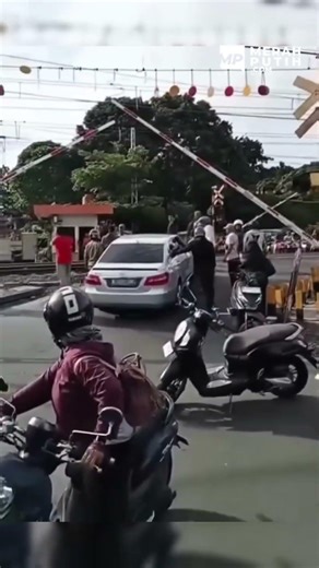 Diduga alami mati mesin di perlintasan kereta api mobil sedan ini diselamatkan warga.