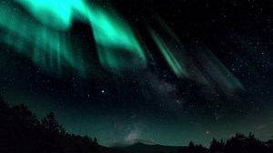 Aurora Borealis interweaving with the Milky Way Galaxy. Northern Lights Time Lapse Solar Wind. Dance of Celestial Lights. Northern Lights twirling with solar wind flaring in green and purple