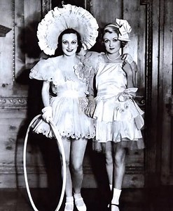 "Circa the spring of 1931, Joan Crawford and her first husband, Douglas Fairbanks Jr., were photographed alongside their close friend, actor and interior designer Billy Haines, at a lavish costume party hosted by Marion Davies at San Simeon—the palatial estate of publishing magnate William Randolph Hearst in coastal California. The fête, attended by Hollywood’s elite including Gloria Swanson, Charlie Chaplin, and Norma Shearer, unfolded beneath soaring vaulted ceilings and moonlit terraces, with