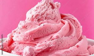 A close-up of pink ice cream with a creamy texture in a white bowl against a pink background, looking delicious and appetizing