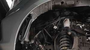 The master sprays an anti-corrosion compound on the bottom of the car.