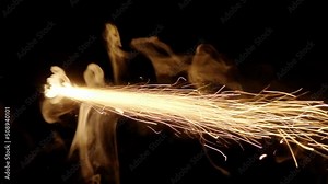 A professional fuse used to ignite bengal fires or bombs, lit with a lighter, burning in slow motion in the darkness. Ending part.