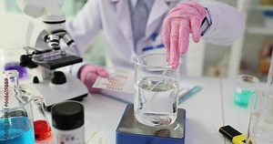 Scientist and test strip with indicators of different colors for liquid analysis. Testing toxic poisonous solvents in laboratory
