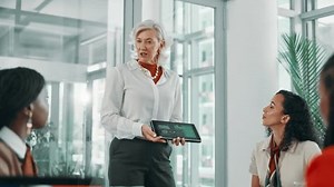 Business, machine learning and tablet with mature woman in boardroom for development workshop. Artificial intelligence, seminar and technology with employee people in office for training course