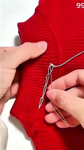 White thread loops, red fabric holds rhythm in stitches