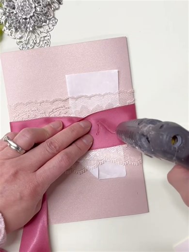 Stephita Wedding Invitations. Closing up a custom trifold wedding invitation with dusty pink ribbon, lace and a rhinestone brooch. . . . #wedding #weddingtiktok #weddingday #weddingvibes #weddingplanning