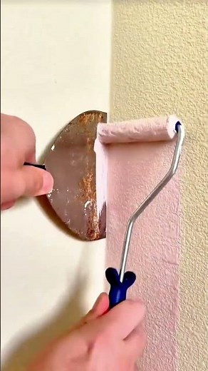 A steady hand guides fresh paint along the wall, creating a smooth and clean finish