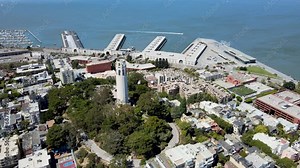 Drone footage of Coit Tower overlooking the urban grid of San Francisco. Ideal for travel and historical content.