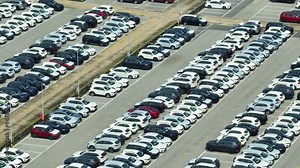 From above, a drone captures the impressive sight of a new car inventory, neatly lined up in rows, waiting for eager buyers. Car industry: Shaping transportation with cutting-edge technology. 4K.