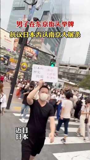 男子在东京街头举牌，抗议日本否认南京大屠杀 南京大虐殺の日本による否定に抗議するために東京の路上でプラカードを掲げる男性