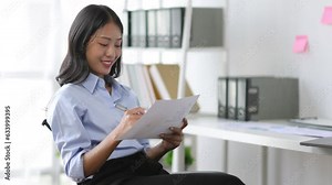 Businesswoman secretary reading document and working on paperwork in the office.