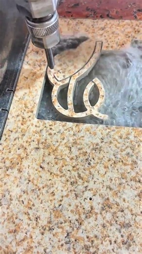 Waterjet streams cut granite, script emerges, stone yields to fluid precision