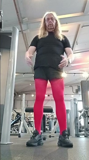 Mann in roter Strumpfhose im Fitness Studio