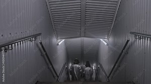 workers in shiny fireproof suits walk down a clean factory corridor.
