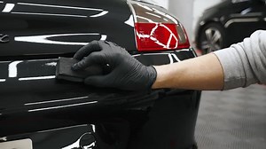 Slowly vertical movement of applying ceramic coating on rear part of the car body by an expert. Close up shot. . High quality 4k footage