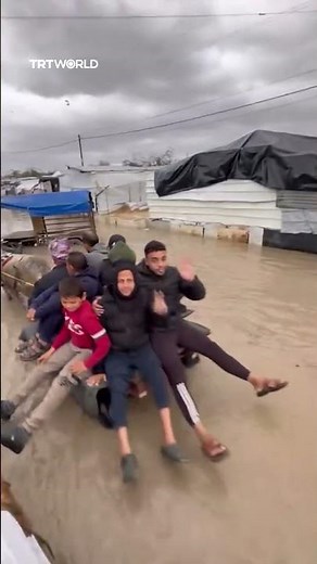 Palestinians travel through knee deep water as heavy rains submerge Gaza’s streets