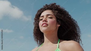 Black beautiful attractive afro young cute girl, curly hair, bikini, famous beach Rio de Janeiro, Brazil. Latin summer vacation holiday. Cinematic 4K.