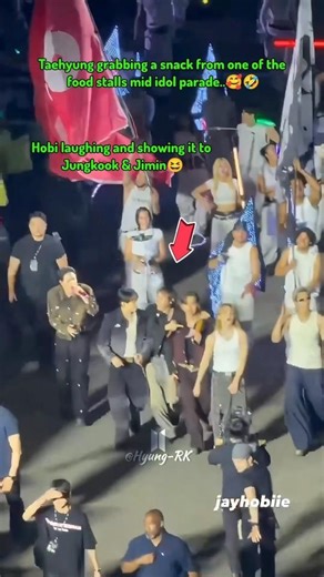 Taehyung grabbing a snack from one of the food stalls mid idol march..🥰🤣