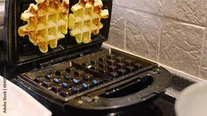 The process of making waffles in an electric waffle iron. A simple, quick and delicious dessert.