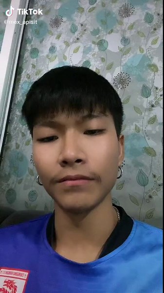 Person in Blue Shirt Sitting on Floral Couch