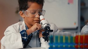 clip-3631796413-boy-checking-sample-under-lab-microscope-girl