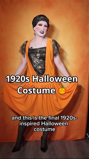 Did you know that flappers wore Halloween costumes?! 🎃 Video description: Taipei is a drag queen wearing dramatic 1920s inspired to make up and a short brown wig in front of an orange background. She begins the video in a black vintage fringe dress. She walks through a quick Vlog style explanation of how she made a 1920s inspired Halloween costume. The costume includes a black stretch velvet slip dress with spiderweb mesh overlay, and a pumpkin orange overdress with a plunging neckline and gath
