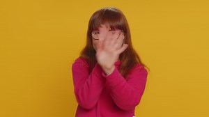 Frustrated young school girl kid covering ears ignoring unpleasant noise loud voices avoiding advice