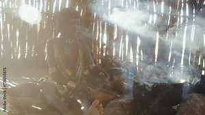 Hamer tribe Mother and daughter in a hut making food