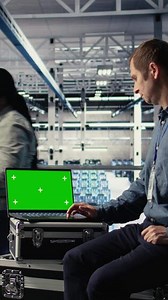 Vertical Data center IT experts investigate AI configurations using green screen laptop, making adjustments. Server hub engineers check deep learning errors on chroma key notebook, camera A