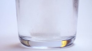 Effervescent dissolving fizzy tablet in water glass. Medicament or tasty drink. Health care theme.