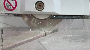 Industrial machine for stone production at manufacturing plant. Machine is cutting stone material at production facility. Automated machine processing granite at stone material production factory