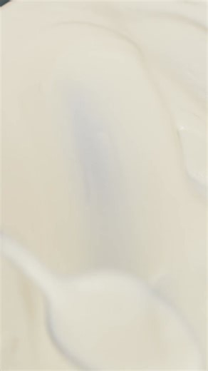 Hand uses back of spoon to cover and smooth white cream mixture over dessert, vertical | 프리미엄 스톡 동영상 자료