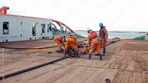 Anchor-handling Tug Supply AHTS vessel crew preparing vessel for static tow tanker lifting. Ocean tug job. AB and Bosun on deck. Good teamwork
