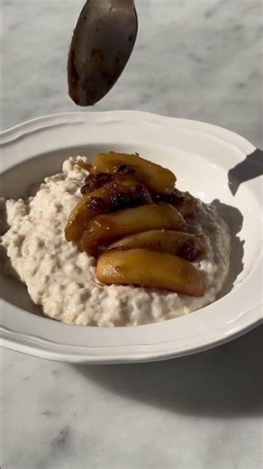 The perfect winter breakfast: Porridge with cinnamon apples and sultanas, maple syrup nuts and cream
