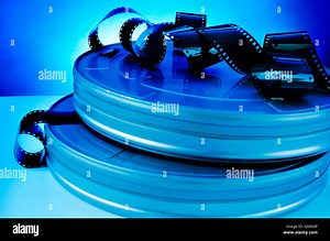 some film strips and metal movie film reel canisters on a table with a blue toning Stock Photo - Alamy