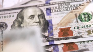 Wad of 100 american dollars money on blurry background. Cash banknotes close up view.