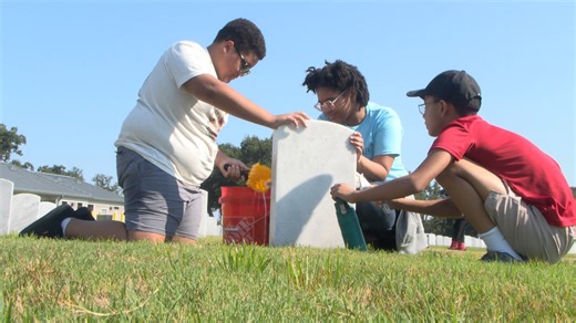 Veterans and students clean headstones of fallen military members