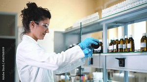 Beautiful young woman scientist in laboratory working. Young female scientist doing some research.
