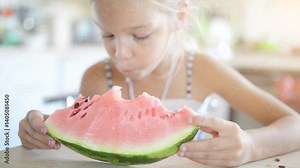 Beautiful blonde small girl eating watermelon