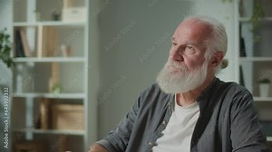 Serious Old Man Sits at the Table and Drinks Coffee. Relaxed Elderly Man Drinking Cup of Tea. Coffee for the Elderly. Tea for the Elderly.