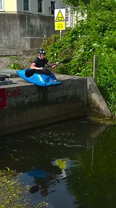 Kayaker drops off weir wall and nails the roll