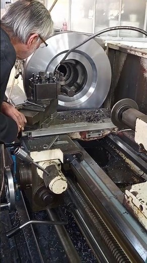 VETERAN SHOWING OFF HIS MACHINING SKILLS ON PARALLEL MANUAL LATH IN MECHANICAL WORKSHOP