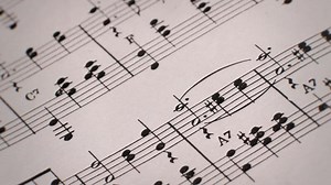 Vintage close-up of musical note paper and turntable spinning, retro aesthetics