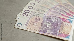 Polish zloty banknotes featuring national symbols and historical figures spread on a concrete surface emphasizing the country's currency and financial system. Stock Video