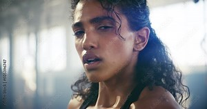 Boxing, sweating and face of woman in gym for martial arts, workout and strong. Focus, health and cardio with female boxer and punching in fitness center for training, exercise and performance