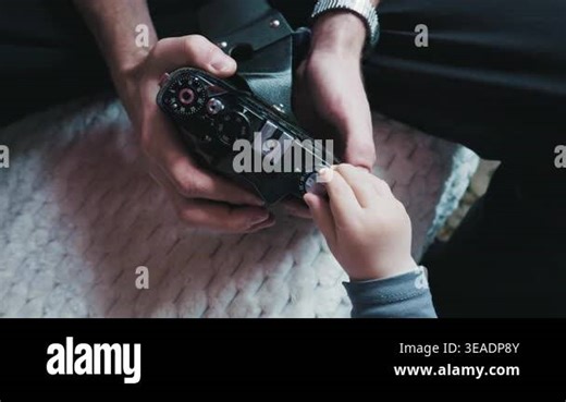 Adult and small baby hands gently hold and explore the mechanical dials of a classic black analog film device. Concept of passing knowledge between generations and family bond Stock Video Footage - Alamy