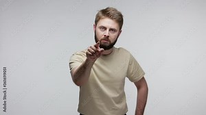 Hey you! Angry bearded guy noticing the guilty and pointing finger at camera, looking strict angry, dissatisfied with behavior, accusing for troubles. indoor studio shot isolated on gray background