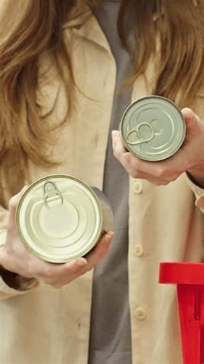 clip-4183200215-vertical-close-up-woman-comparing-two-cans-pet